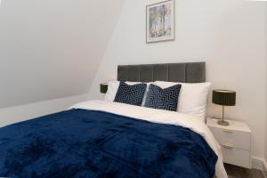 a bedroom with a blue blanket on a bed at Modern, Stylish, cosy, Finchley London 3 Bed 2 bath Apartment with Free Parking in Whetstone