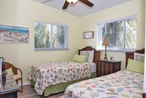 a bedroom with two beds and two windows at Parrot Eyes in Tavernier