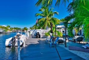 a marina with palm trees and a dock with boats at Parrot Eyes in Tavernier
