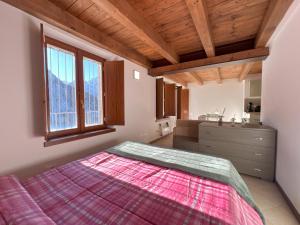 a bedroom with a large bed and a kitchen at Affittimoderni Ponte di Legno Ski - PDL23 in Ponte di Legno