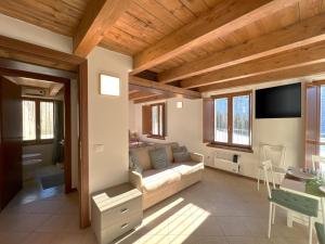 a living room with a couch and a tv at Affittimoderni Ponte di Legno Ski - PDL23 in Ponte di Legno