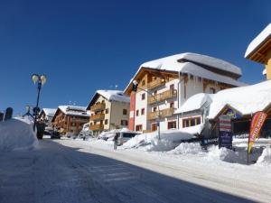 a street covered in snow with buildings in the background at Affittimoderni Ponte di Legno Ski - PDL23 in Ponte di Legno