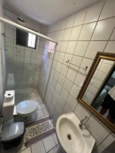 a bathroom with a sink and a toilet and a mirror at Dunas Hostel in Natal