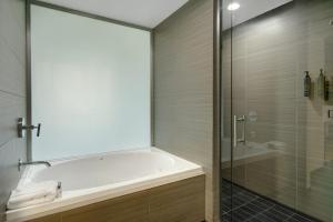 a bathroom with a tub and a glass shower at Aloft Oklahoma City Downtown – Bricktown in Oklahoma City