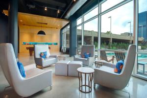 vestíbulo con sillas, mesa y piscina en Aloft Oklahoma City Downtown – Bricktown, en Oklahoma City