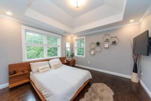 a bedroom with a bed and a flat screen tv at Ultra-Luxurious Home near Boston (Pet-Friendly) in Waltham