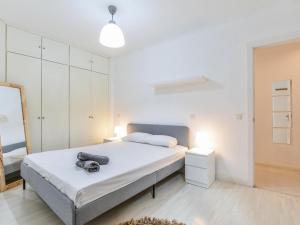 a white bedroom with a bed and a mirror at apartamento cava baja in Madrid