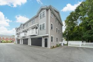 um grande edifício cinzento com uma cerca branca em Ultra-Luxurious Home near Boston (Pet-Friendly) em Waltham