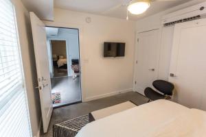 a bedroom with a bed and a sliding door with a television at Moon 401 - Half Moon Suite - 2BR - 2 Bath in New Orleans