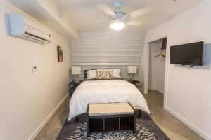 a bedroom with a bed and a flat screen tv at Moon 401 - Half Moon Suite - 2BR - 2 Bath in New Orleans