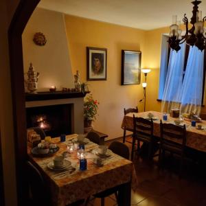 ein Esszimmer mit 2 Tischen und einem Kamin in der Unterkunft A Collodi Io & Mamma in Collodi