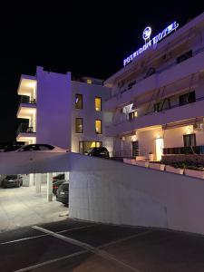 ein Hotelgebäude mit einem Parkplatz in der Nacht in der Unterkunft Poseidon Hotel in Ksamil