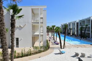 een uitzicht op een resort met een zwembad en palmbomen bij Wave Plus Apartments in Lido di Jesolo