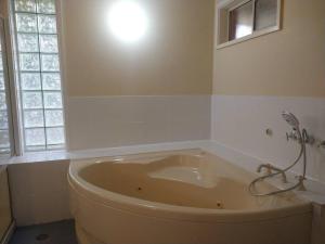 a large tub in a bathroom with a window at Happy Spacious Home nr Canberra Hospital in Harman