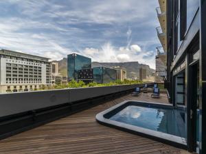 a balcony with a swimming pool on top of a building at Luxury City Living - 2 Bedroom Apartment in Cape Town