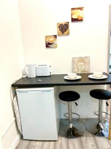 a black counter with two stools in a room at Brilliant One Bedroom Flat in London in London