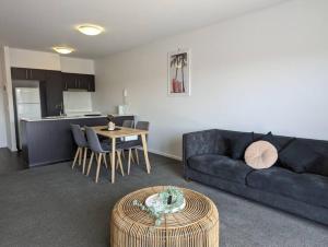 a living room with a couch and a table at Serenity at Stromlo 2bd 1br at Wright in Weston Creek