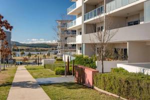 a apartment building with a sidewalk next to a building at Serenity at Stromlo 2bd 1br at Wright in Weston Creek