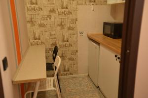 eine kleine Küche mit einem Tisch und 2 Stühlen in der Unterkunft Uneed Rooms - Cloud 9 in Kiew