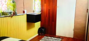 a room with a yellow wall and a door at Moonsong Accommodation & Camping in Plettenberg Bay
