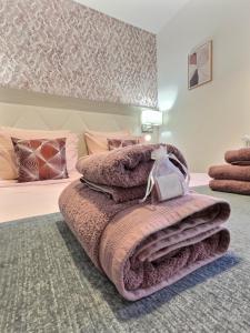 a bedroom with a bed with a pile of blankets at Les Platanes in Gorrevod