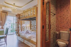a bedroom with bunk beds with a toilet and a bathroom at Ma Muan Budget & Boutique Chiang Mai in Chiang Mai