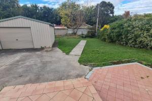 a yard with a garage and a driveway at Comfortable Home 3bdr Nr Kingston and Fyshwick in Fyshwick
