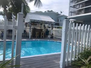 a swimming pool with a white fence around it at Parrot Eyes Upper in Tavernier