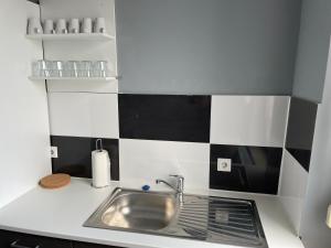 a small kitchen with a sink and black and white tiles at 60m² Wohnung in Krefeld Zentrum, nähe Düsseldorf Hbf, Messe, Zentrum in Krefeld