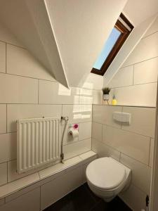 uma casa de banho com um WC branco e uma janela em Großzügige Wohnung im Zentrum em Paderborn