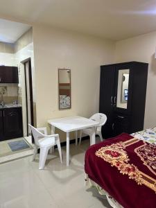 a room with a table and chairs and a kitchen at luule in Al Ain
