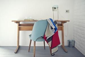 a wooden desk with a chair with a blanket on it at Ceglarnia in Książ Wielkopolski +9 photos