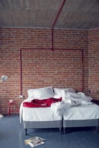 a bed in a room with a brick wall at Ceglarnia in Książ Wielkopolski