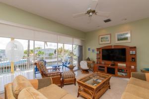 a living room with a couch and a flat screen tv at Pelican Landing in Islamorada