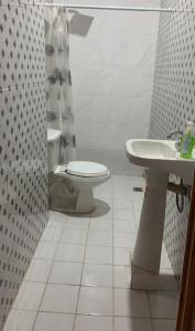 a white bathroom with a toilet and a sink at Casa Hotel Rousse in Tequila