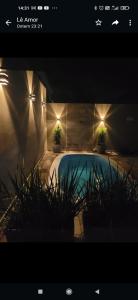 - une piscine avec deux plantes en pot et des lumières dans l'établissement Casa das posses para 8 pessoas, à Serra Negra