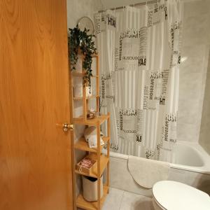 a bathroom with a shower curtain and a toilet at Muralla in Camprodon