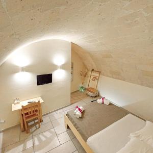 a room with a bed and a table and a tv at Mikasa in Matera