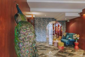 a large peacock statue in a living room at Ma Muan Budget & Boutique Chiang Mai in Chiang Mai