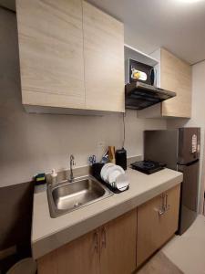 a small kitchen with a sink and a refrigerator at Cavite Budget Airbnb with Resort-like Amenities in Dasmariñas