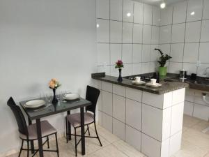 a kitchen with a table and chairs in a room at Kitnet 2 - próximo ao centro de Jacareí in Jacareí