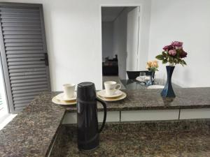 a kitchen counter with two cups and plates on it at Kitnet 2 - próximo ao centro de Jacareí in Jacareí