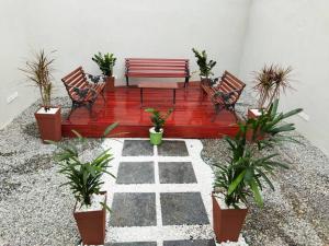 une terrasse avec un banc rouge et des plantes en pot dans l'établissement Kitnet 2 - próximo ao centro de Jacareí, à Jacareí