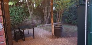 a patio with a table and a tree in it at Happy Haven in Welkom