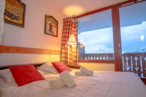 a bedroom with a bed and a large window at Lovely apartment with balcony in Alpe d'Huez - Welkeys in LʼHuez