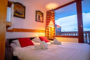 a bedroom with two beds and a large window at Lovely apartment with balcony in Alpe d'Huez - Welkeys in LʼHuez