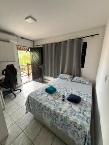 a bedroom with a bed and a desk and a chair at Pousada Dunas Natal in Natal