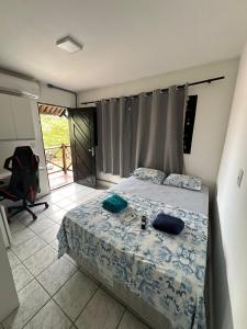 1 dormitorio con cama, escritorio y silla en Dunas Hostel, en Natal