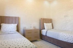 a bedroom with two beds and a nightstand between them at Villa Mogador By Solena in Essaouira
