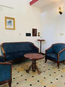 una sala de estar con 2 sofás azules y una mesa. en RiTAS en Varkala